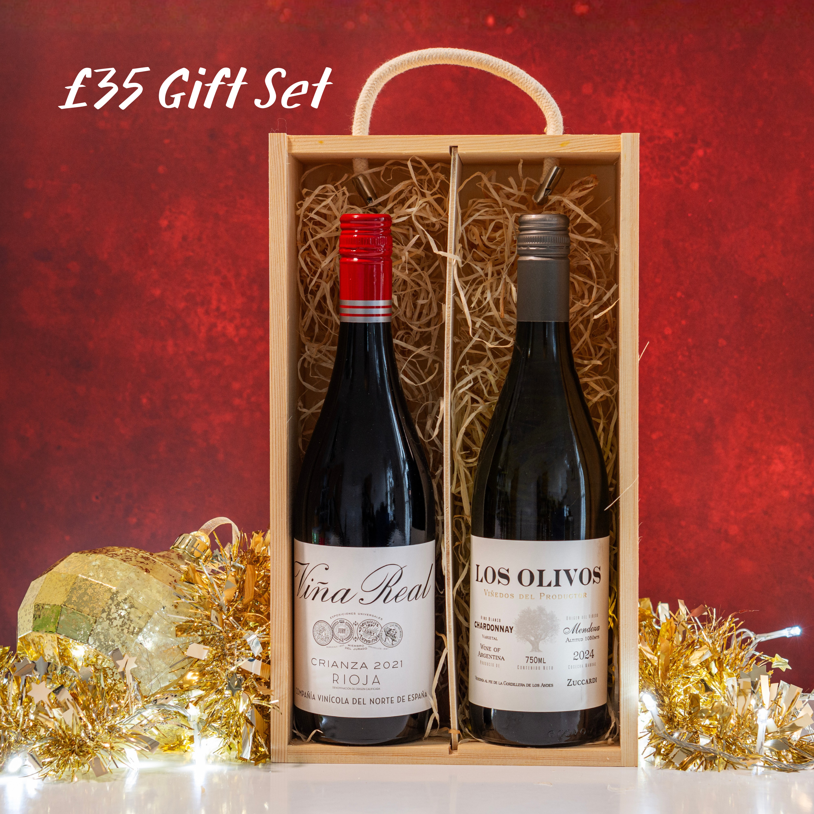 Two wine bottles in a wooden gift box with a red background and decorative elements.