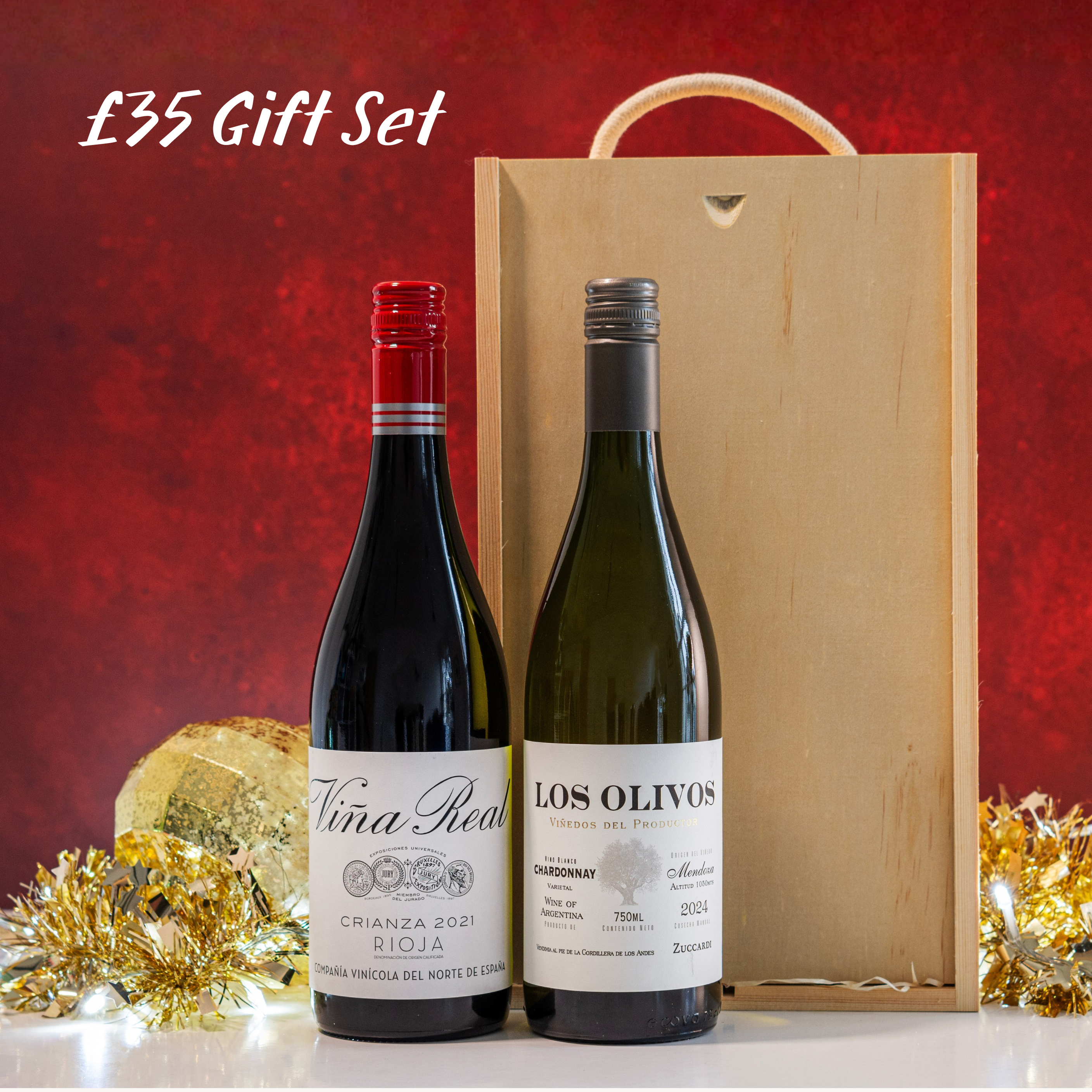 Two wine bottles with a wooden gift box on a red background